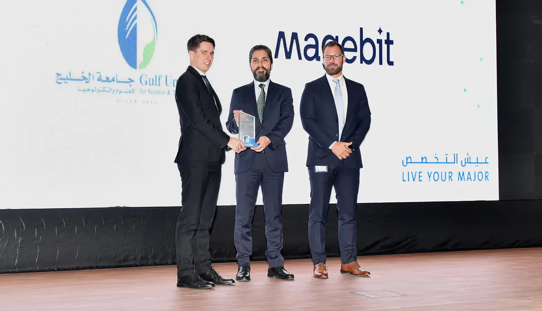 Magebit receiving an award on stage at a Gulf University for Science & Technology event
