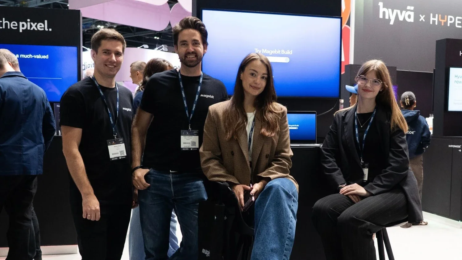 Magebit team at the Hyvä stand at eCommerce Expo 2026 with Magebit Build on screen