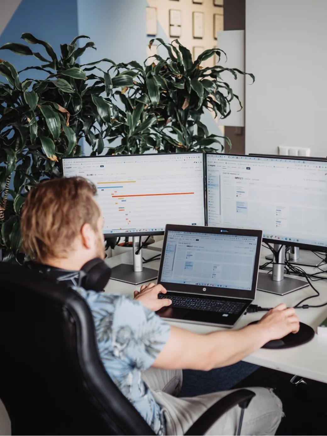 A Magebit engineer working at a multi-monitor workstation