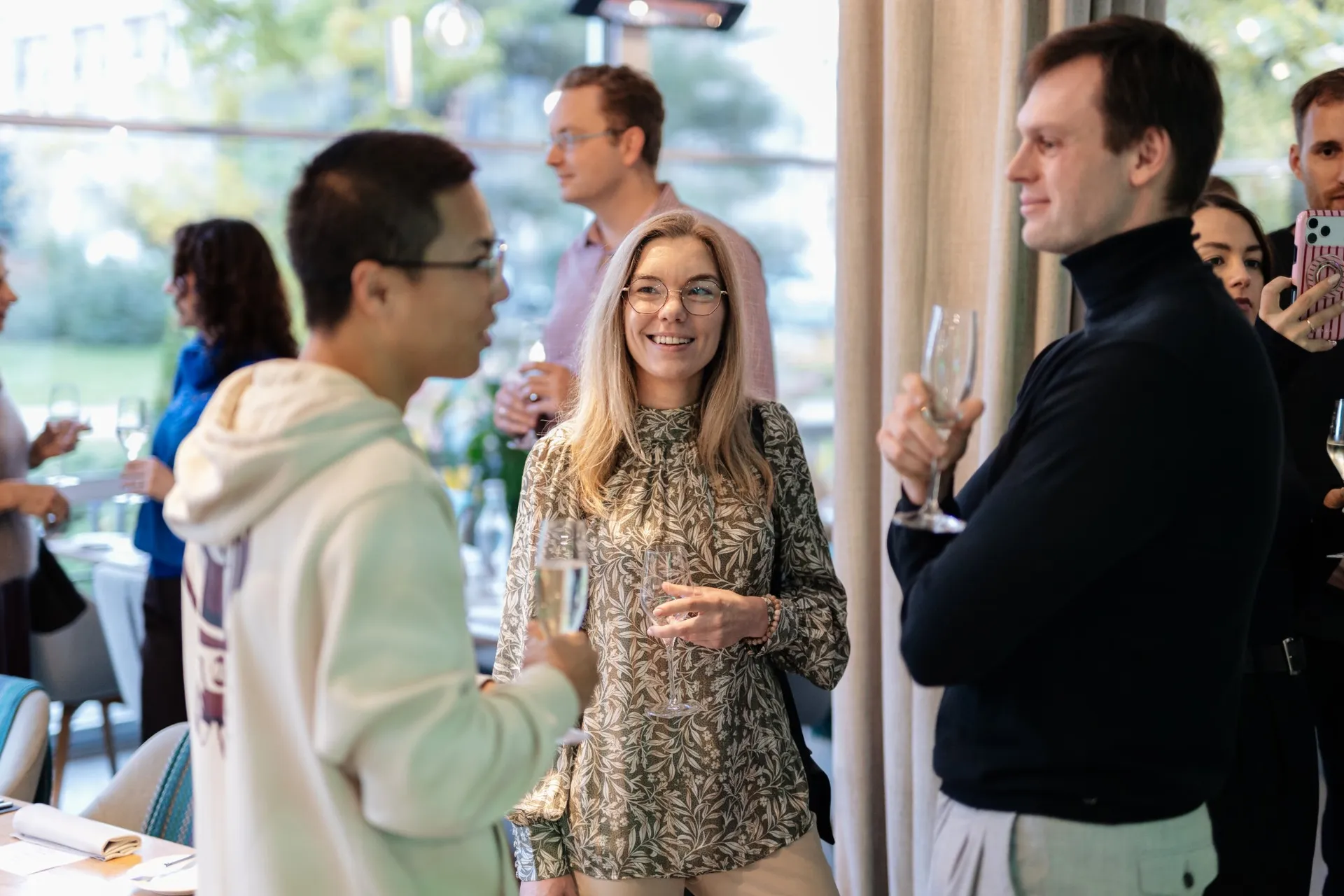 Three guests talking over drinks during the welcome reception at Kolonāde