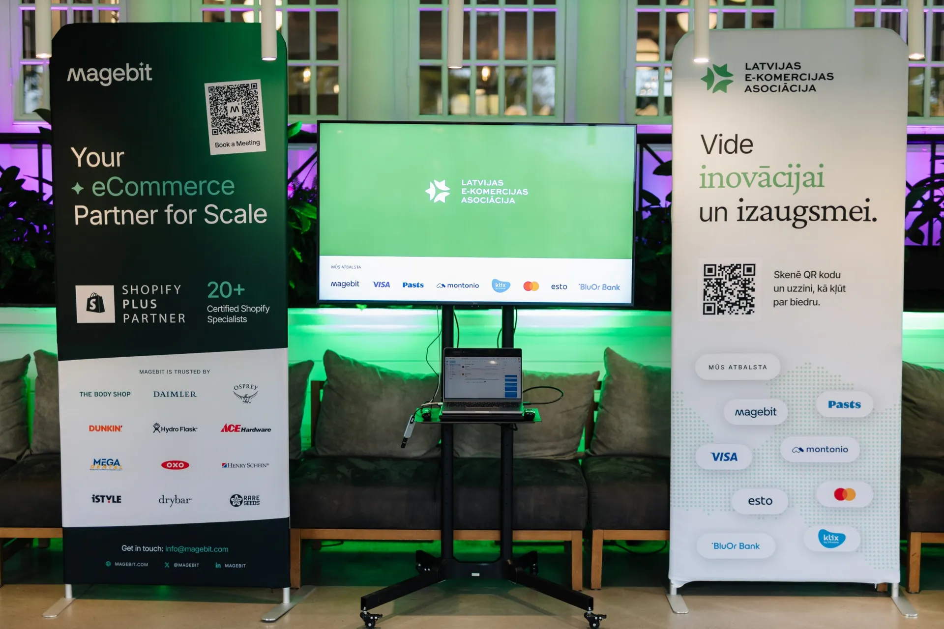 The Magebit and LATEKA banners on either side of a screen showing the Latvian E-commerce Association logo