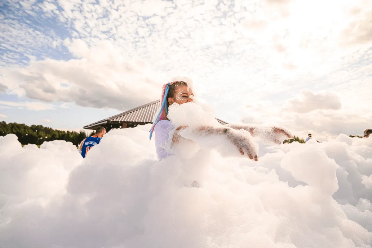 A colleague surrounded by foam at an outdoor party