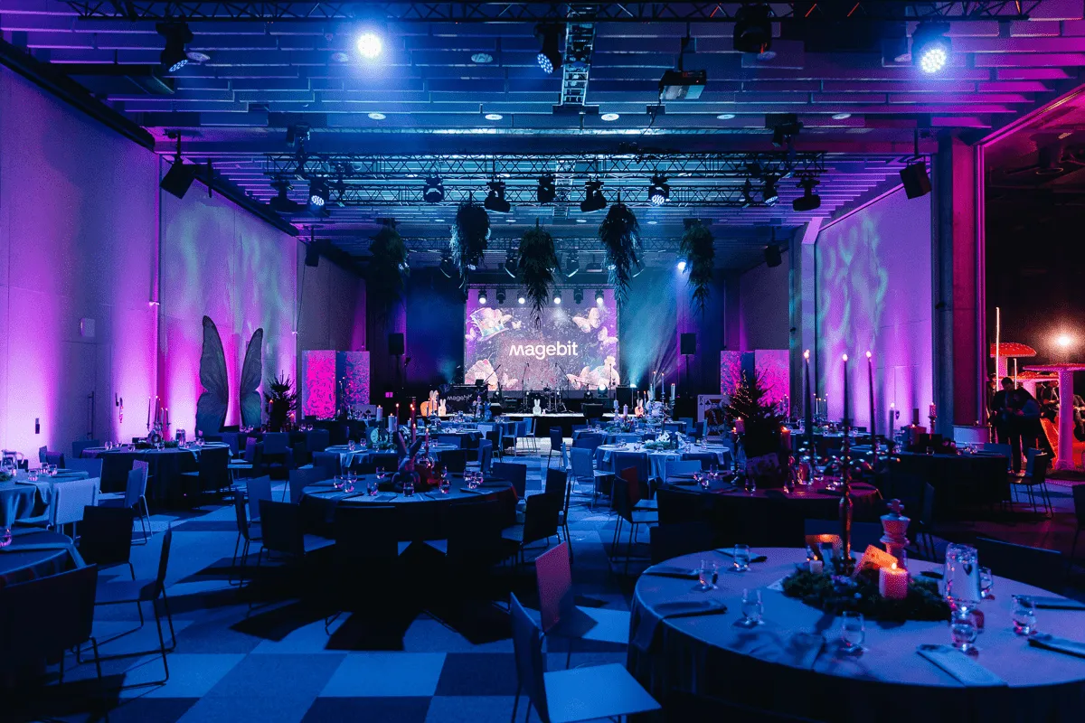 An event hall lit in purple, set for a Magebit party