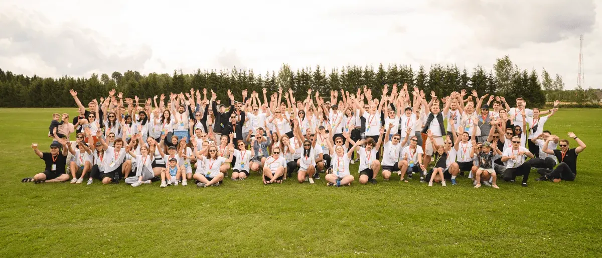 The Magebit team waving in a group photo on a field