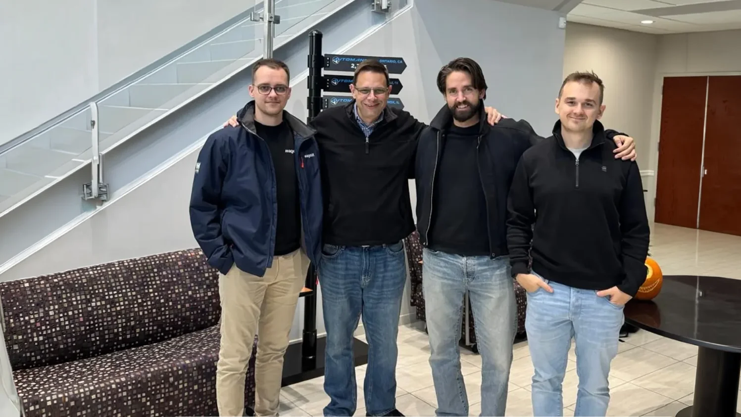 Four members of the Magebit team posing together at the Automann office in New Jersey