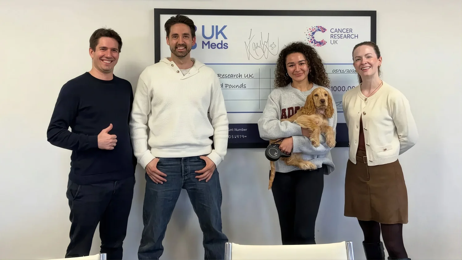 The Magebit team posing with the UK Meds and Cancer Research UK donation cheque in the Nottingham office