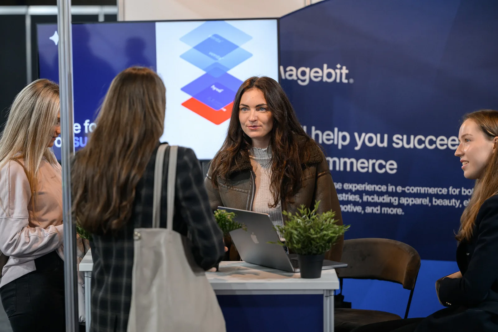 Visitors talking with the Magebit team at the Magebit booth at RIGA COMM 2025