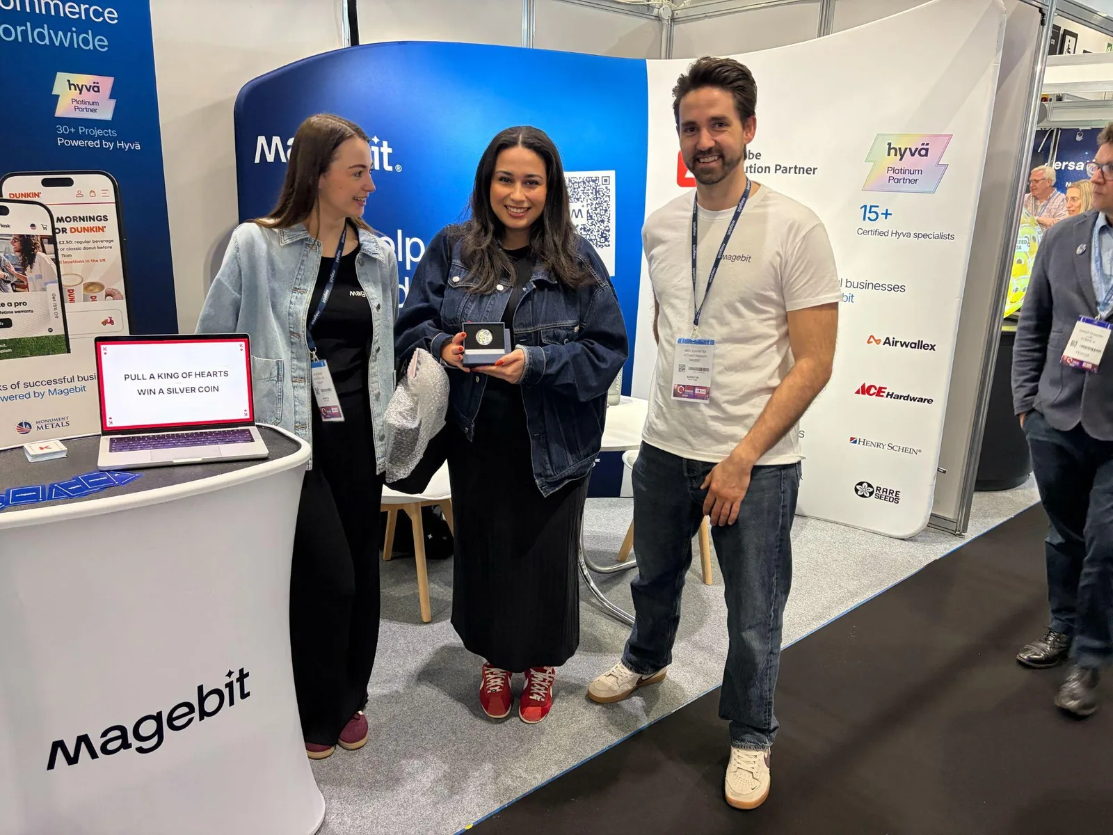 A visitor holding a silver coin won in the card draw at the Magebit stand at Retail Technology Show 2026