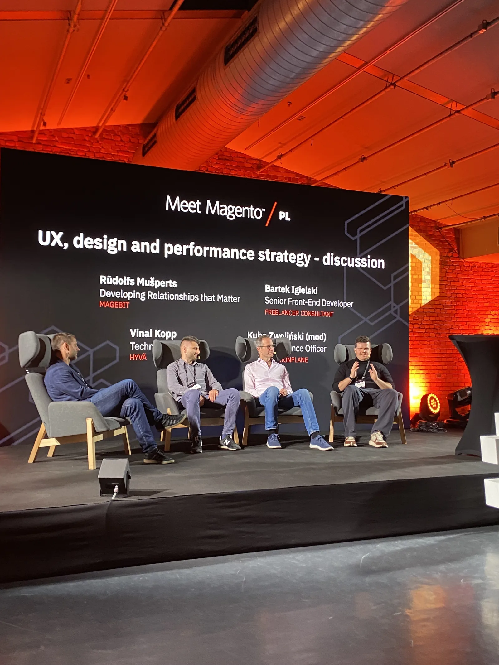 Panel discussion on UX, design and performance strategy on the Meet Magento Poland 2024 main stage, with Rūdolfs Mušperts of Magebit among the panelists
