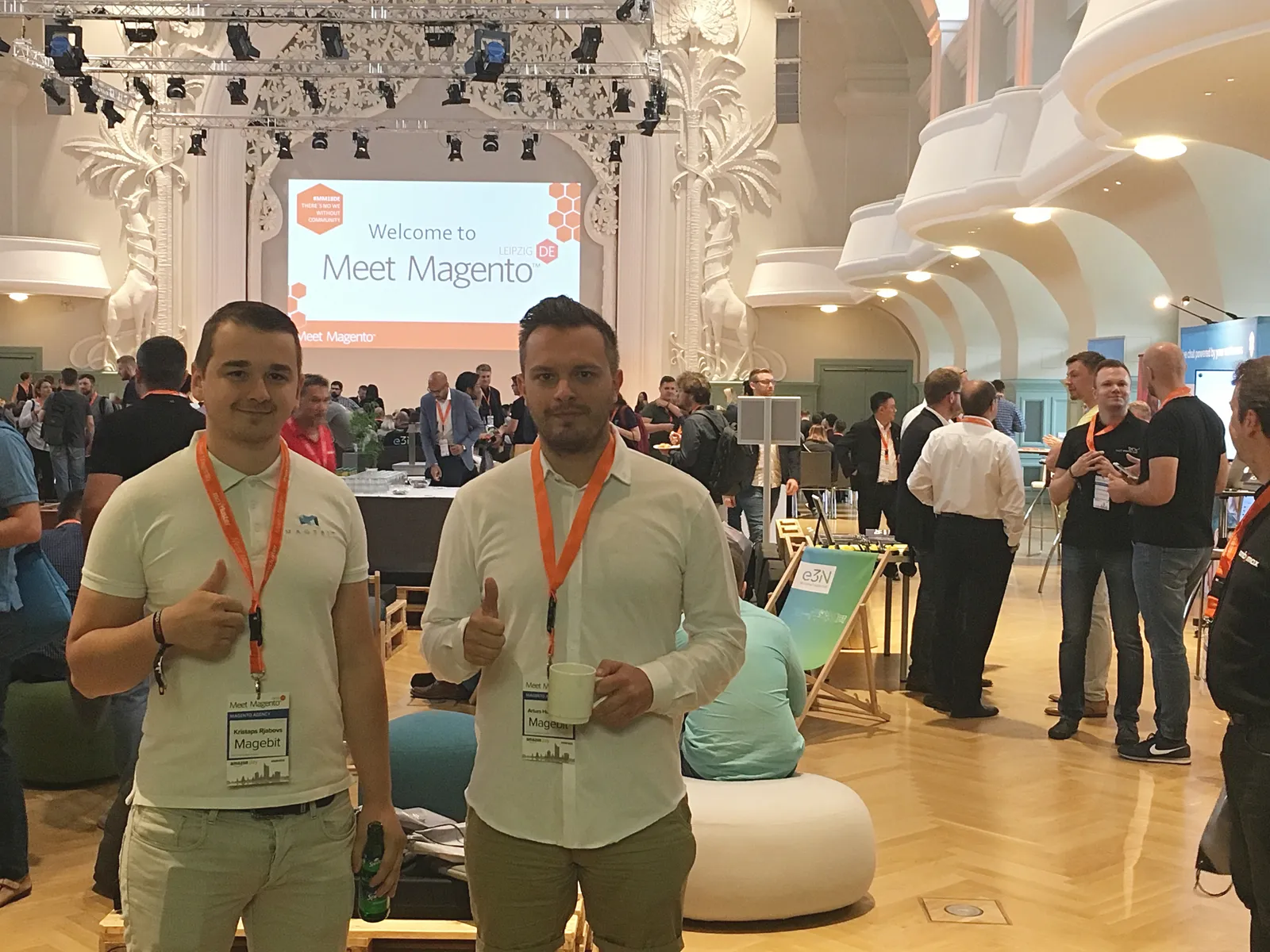 Kristaps Rjabovs and a Magebit colleague with Meet Magento badges in the main hall of Meet Magento Germany 2018