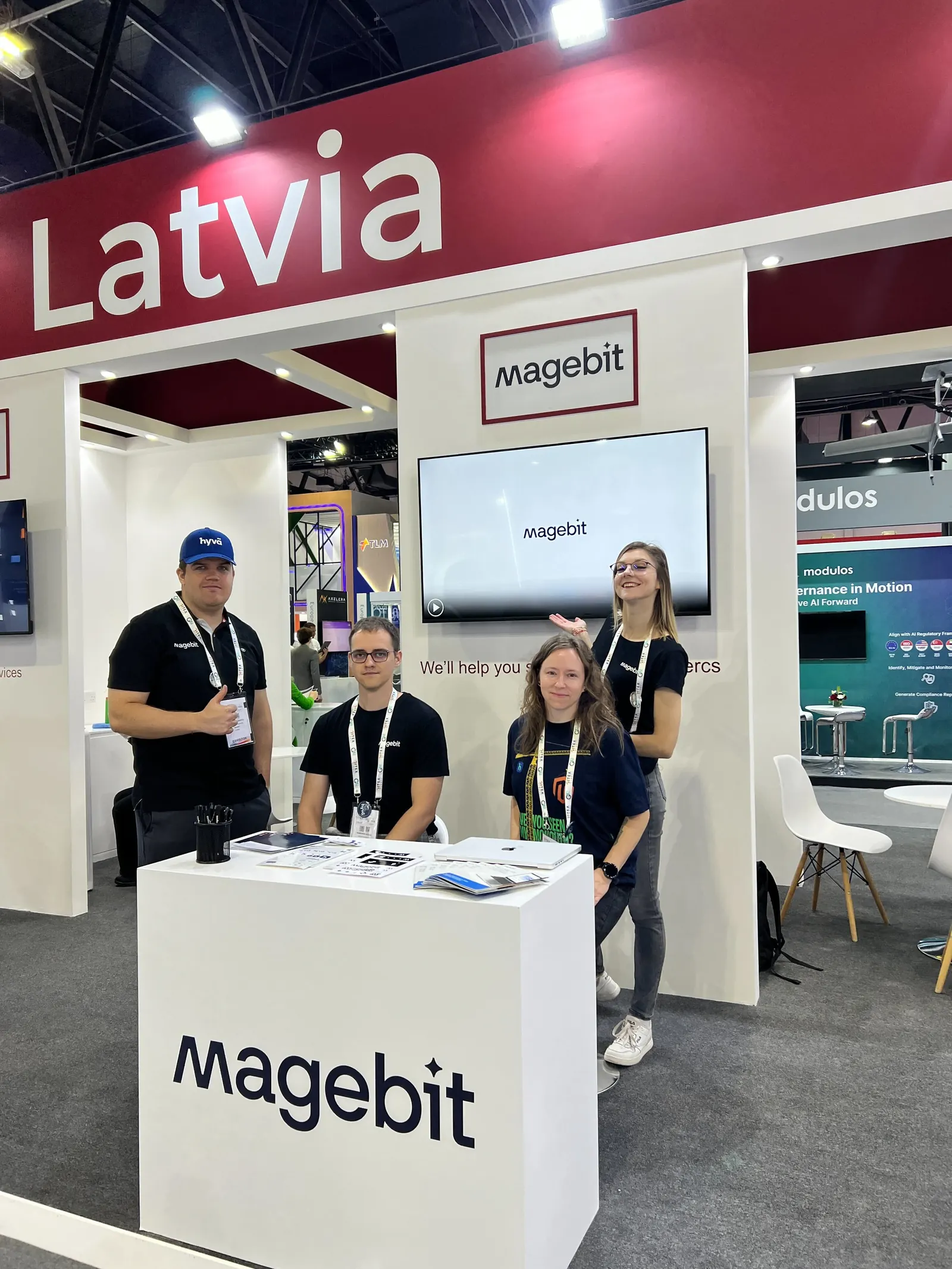 Four Magebit team members at the Magebit stand under the Latvia pavilion sign at GITEX Global 2024 in Dubai