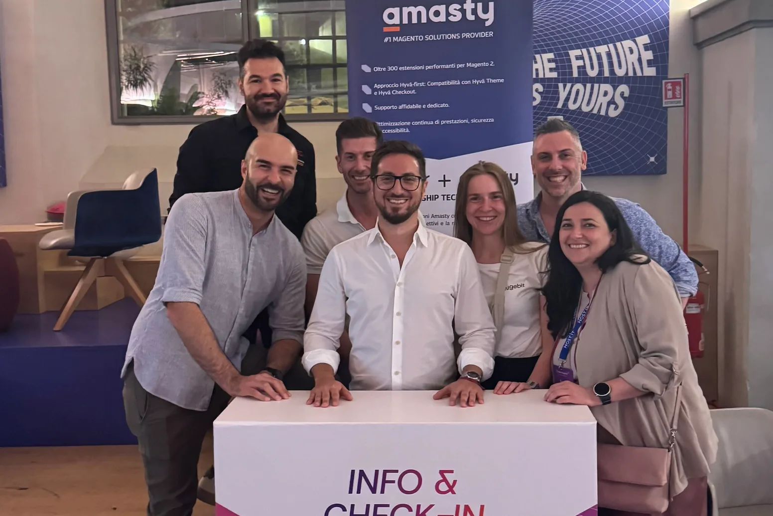 The organising team at the info and check-in desk at Meet Magento Italy 2026