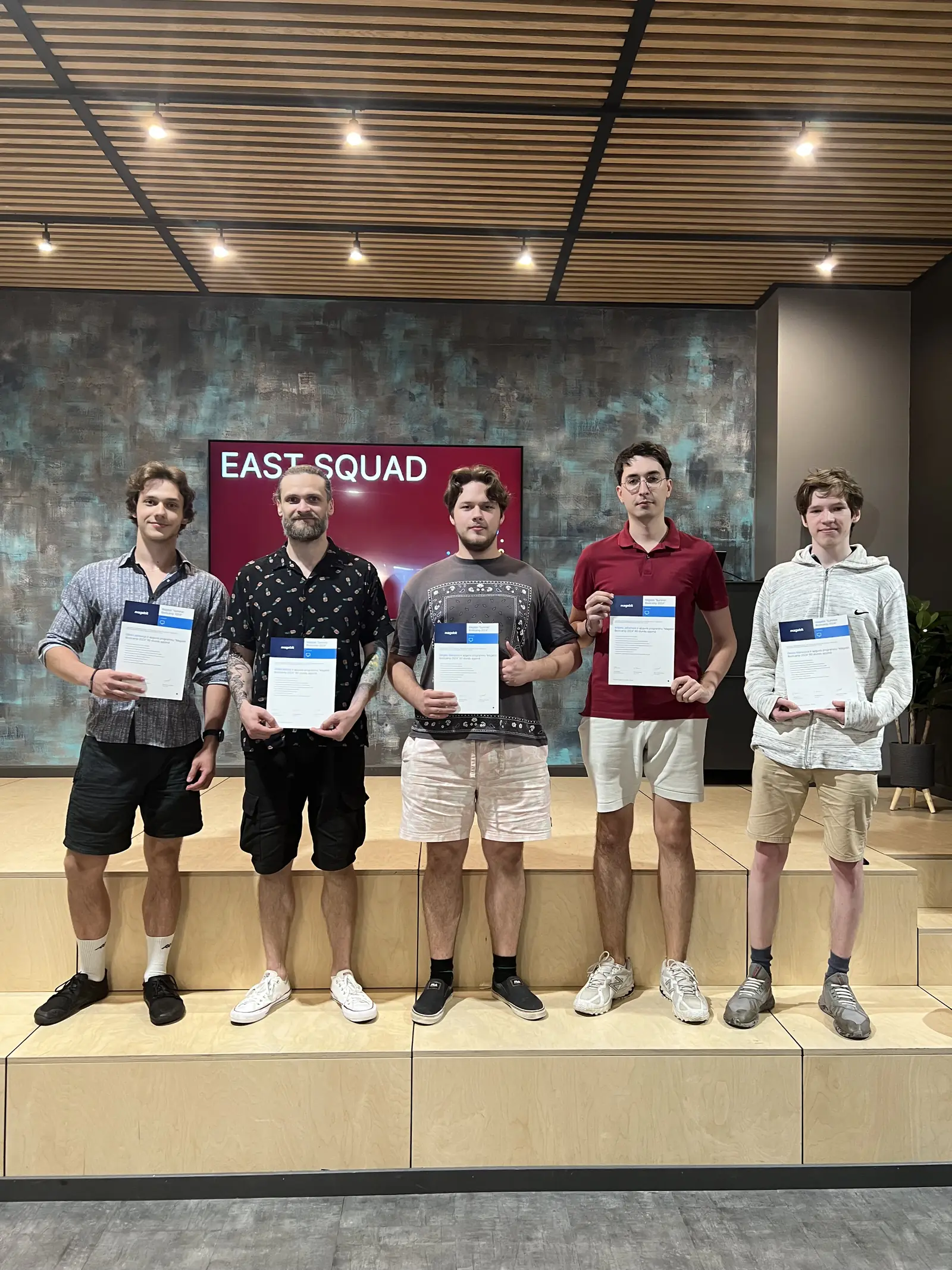 The five members of East Squad holding their bootcamp certificates at the Magebit IT Bootcamp 2024 finale