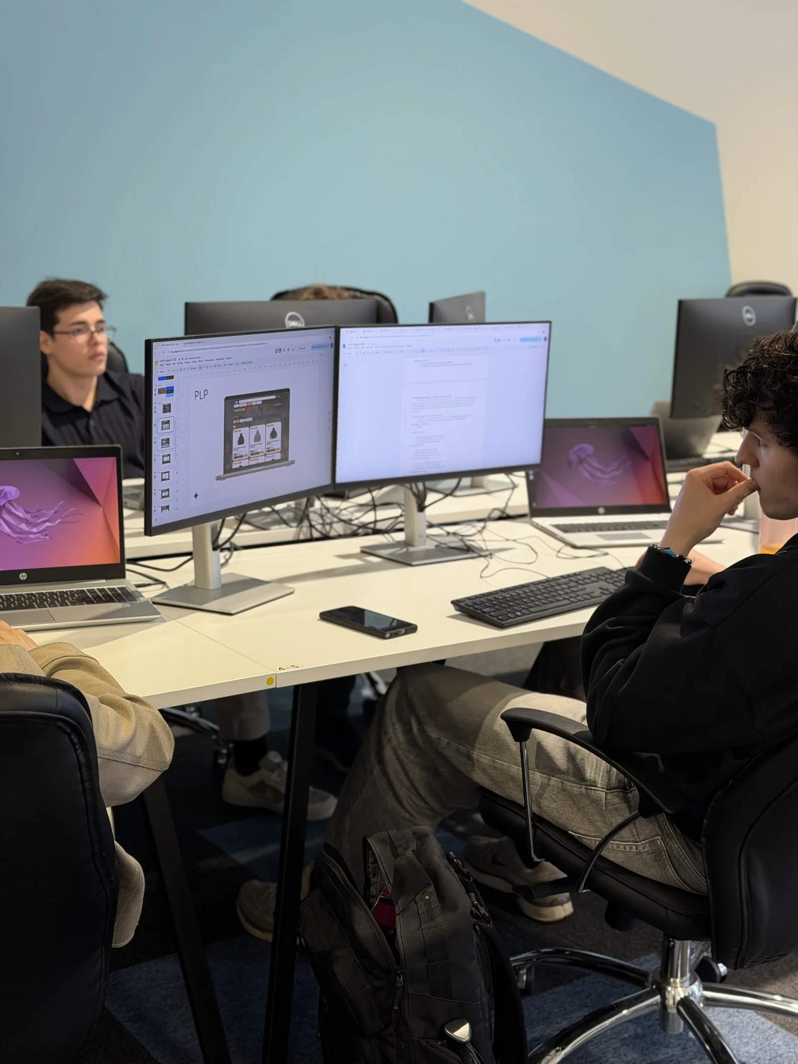 Bootcamp participants working on their final project at dual-monitor workstations