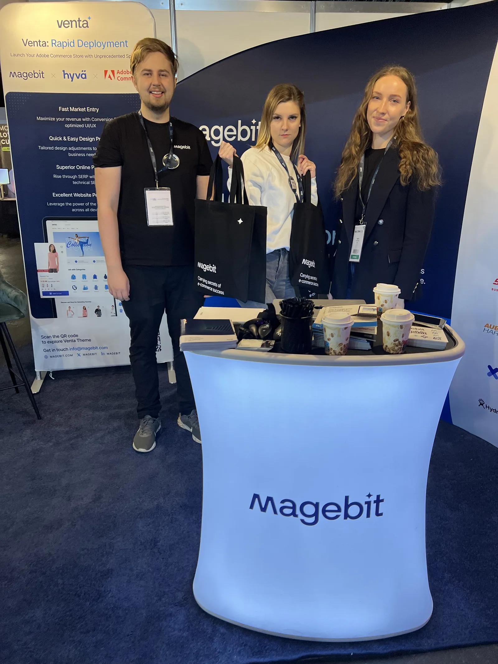 Magebit team with branded bags at the Magebit booth at RIGA COMM 2024