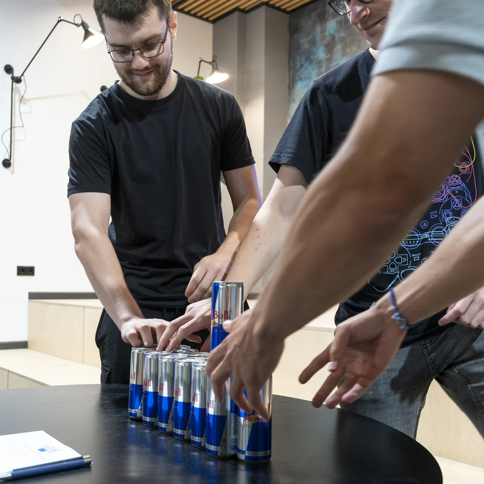 Participants racing to stack Red Bull cans in a team challenge at the Magebit IT Bootcamp 2023