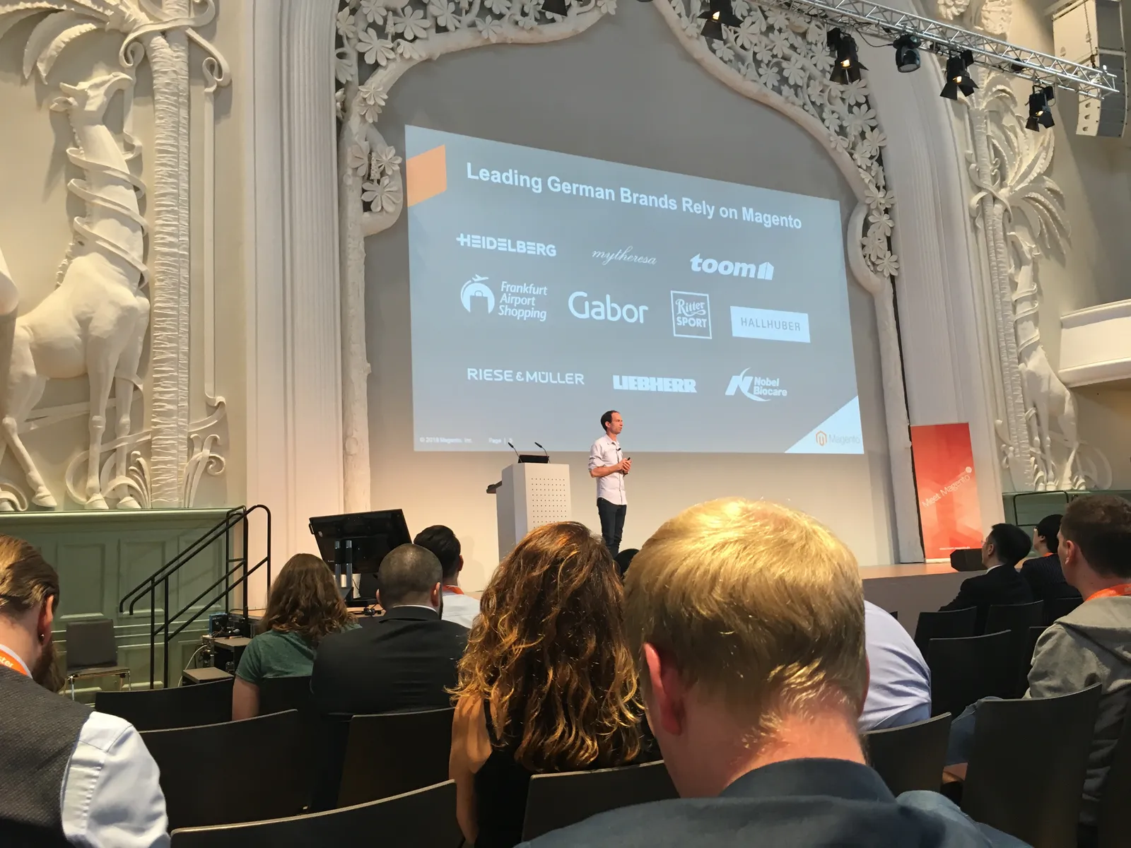 Slide listing leading German brands that rely on Magento, shown on the Meet Magento Germany 2018 stage