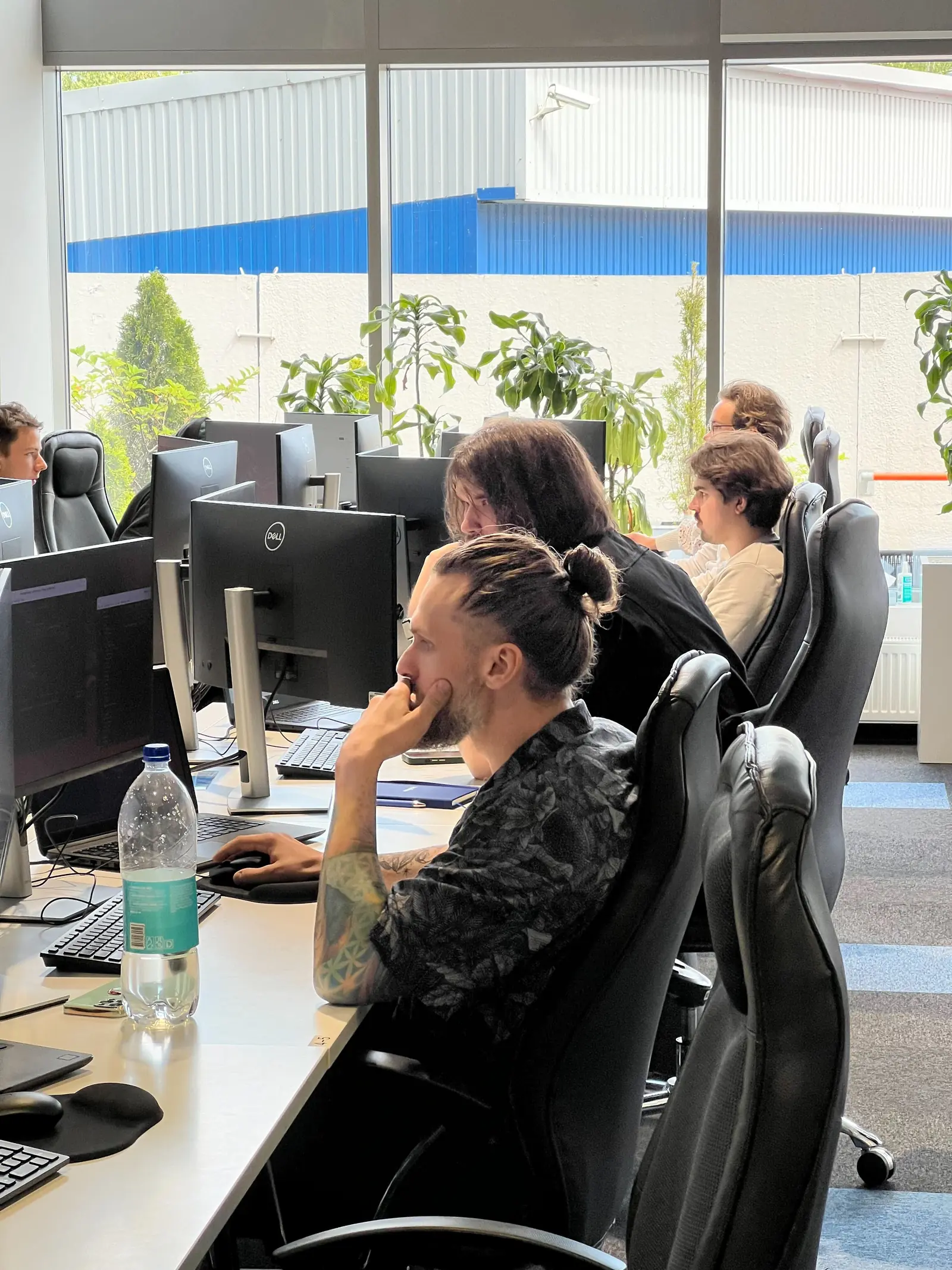 Participants working on their projects at dual-monitor desks in the Magebit office