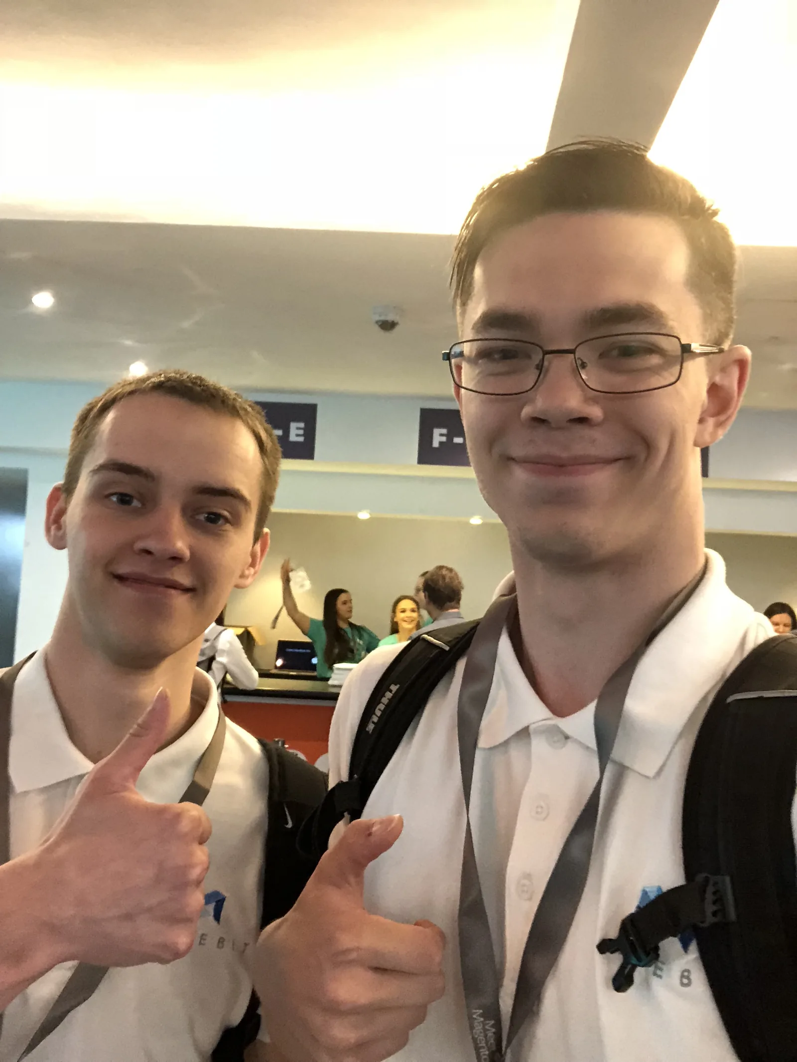 Two Magebit team members with event lanyards at Meet Magento UK 2018