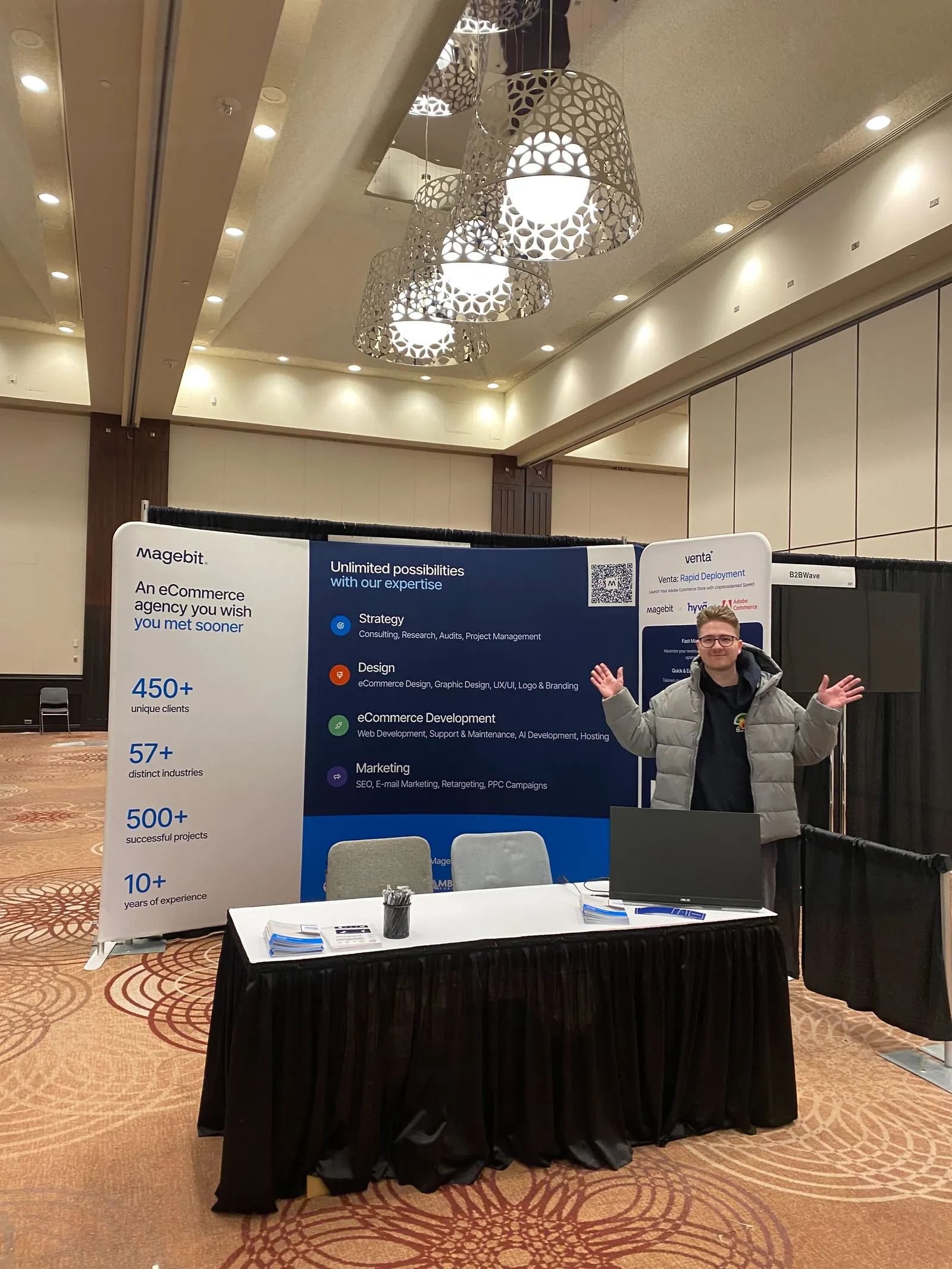 A Magebit team member waving at the finished Magebit booth in the empty exhibition hall before doors opened at DX3 Canada 2025