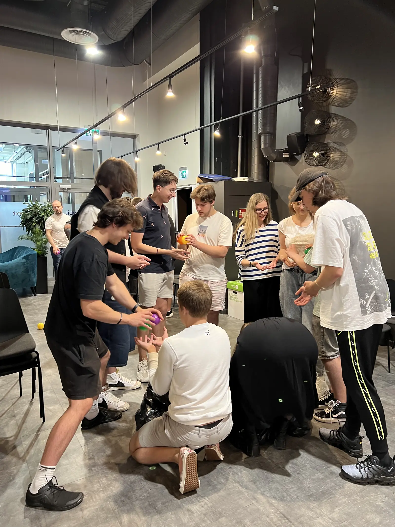 Participants passing coloured balls in a team-building game at the Magebit IT Bootcamp 2024
