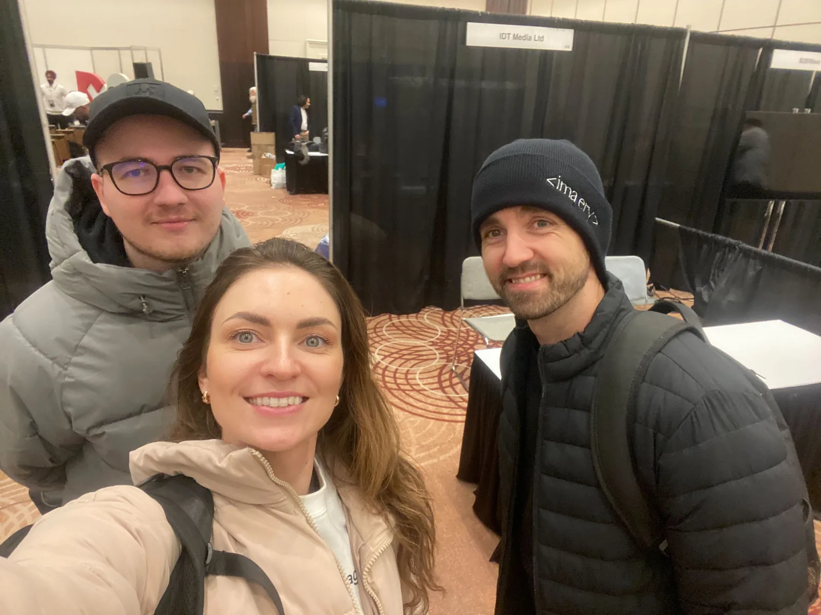Three Magebit team members taking a selfie among the exhibitor booths at DX3 Canada 2025