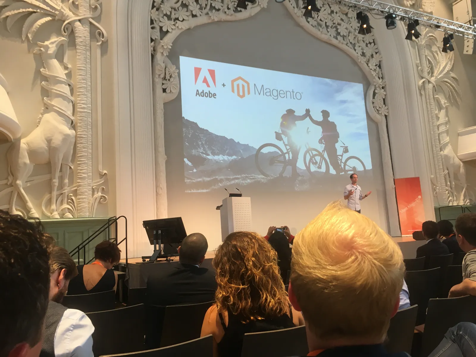 Adobe and Magento logos side by side on the main stage screen at Meet Magento Germany 2018