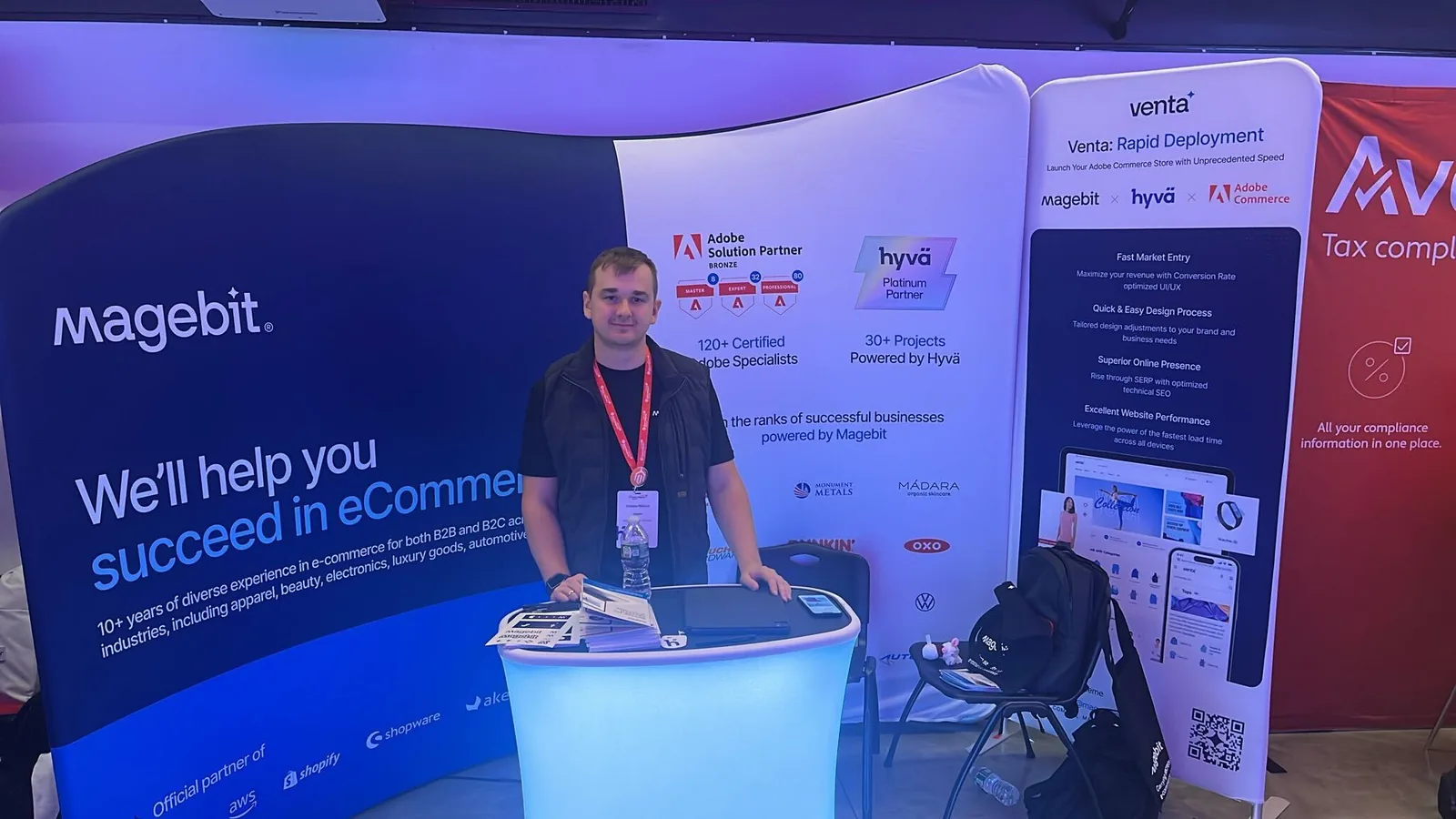 Magebit team member at the illuminated Magebit counter at Meet Magento New York 2024