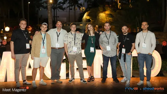 Magebit, Rave Digital and Aheadworks people in front of the illuminated MAGENTO letters at Meet Magento Florida