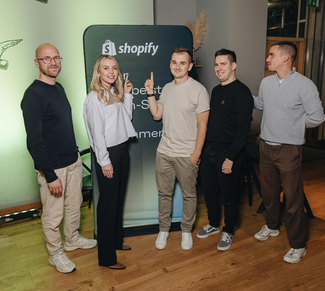 The Magebit team hosting the Shopify Dinner, in front of a Shopify banner