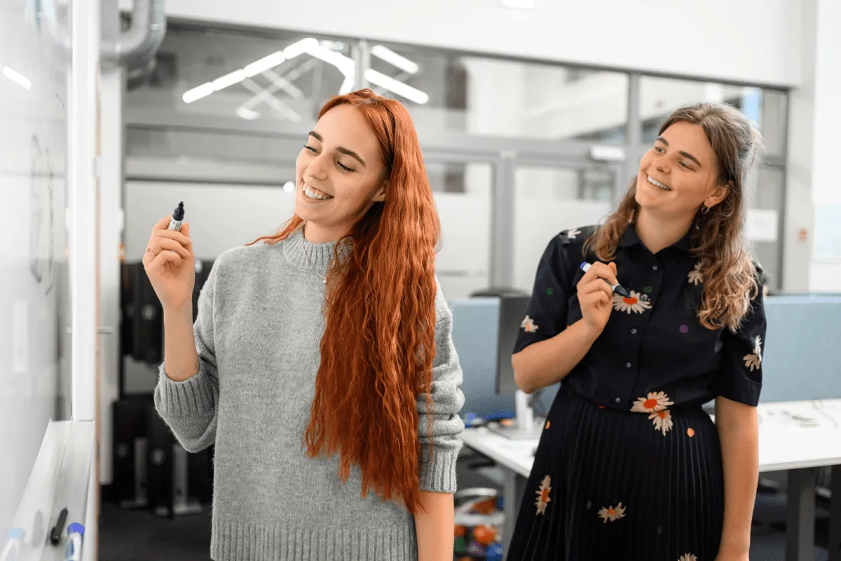 Two Magebit colleagues planning at a whiteboard